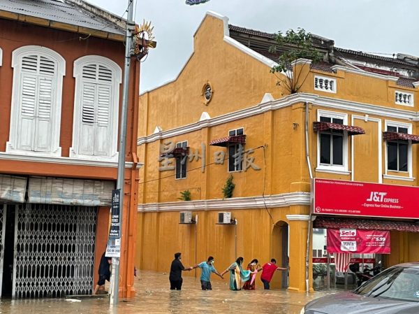 fb:数小时大雨,森州各地传出灾情;灾民手牵手越马路