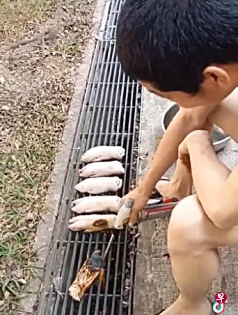 男子用喷火枪 水沟盖上烧猪蹄