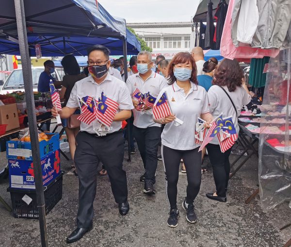 到池龙花园早市 梁德志派千支国旗