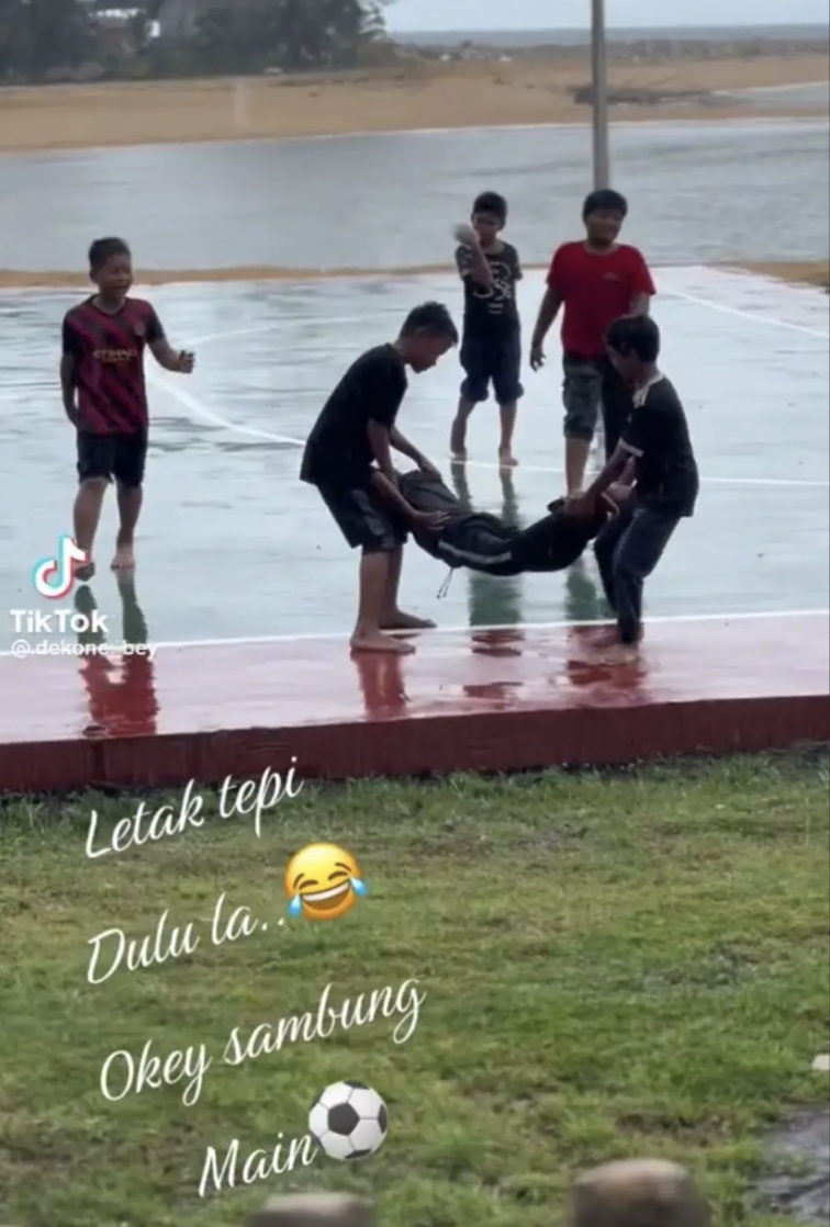 少年雨中踢球滑倒受伤 球友抬场边继续踢球