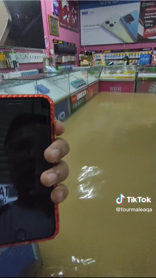 视频|电话店老板遭遇水灾心好疼 边检查电子产品边用泥水洗