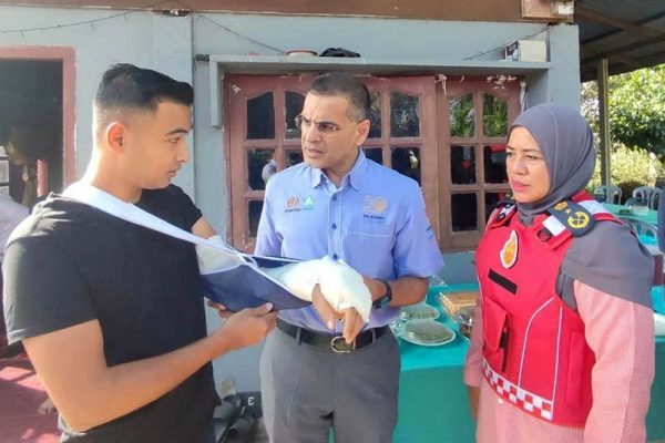 莫哈末阿兹曼（中）移交赔偿金给尼占并慰问其伤势，右為莎雅妮。（图：Sinar Harian）