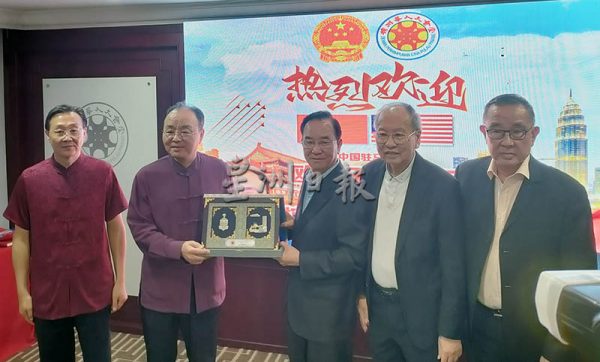 陈坤海(左三)赠送纪念品给欧阳玉靖。左一周游斌、右起黄天隆、许廷炎。(梁杰华摄)