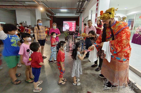 财神爷分派红包给予孩童们。(黄惠玲摄)