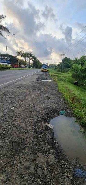 8哩靠近甘榜马来尤路口的紧急车道出现多个积水坑洞,形成危险陷阱。(取自脸书)