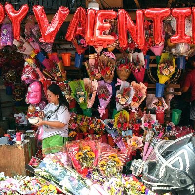 People buy bouquets of flowers at a flower market in Manila on Valentine's Day. AFP