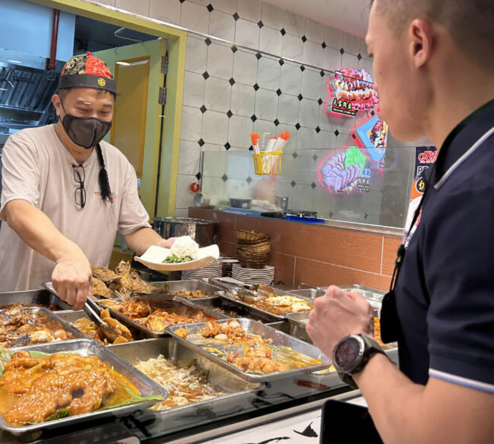 **已签发**柔:狮城二三事:菜饭摊助手变身“财神爷”添饭夹菜,食客赞妙纷拍照