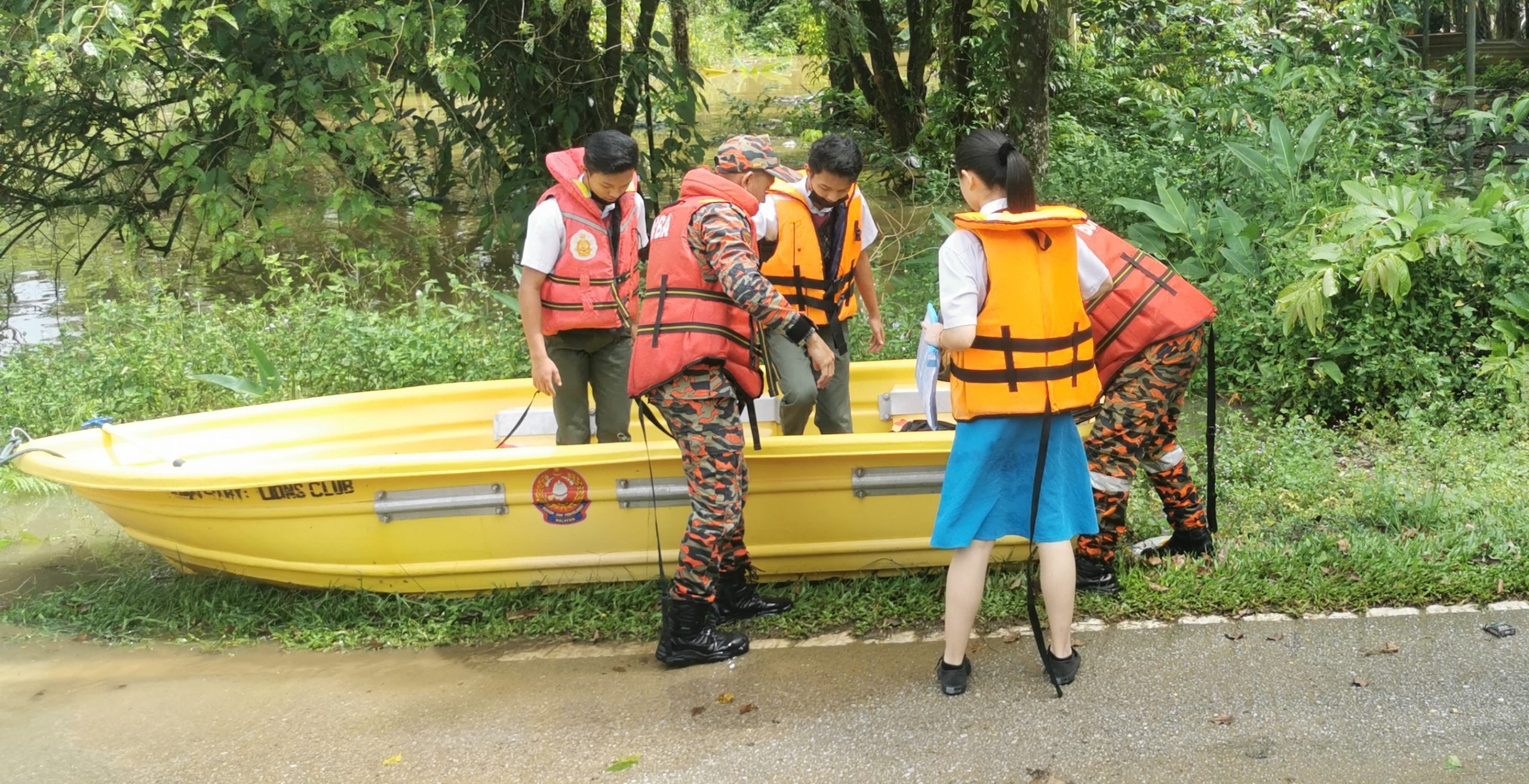 消拯员协助考生越过淹水区前往学校考试