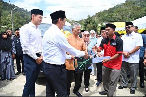 华商在国家元首苏丹阿都拉陛下见证下,捐赠载客货车予金马仑瓜拉博原住民村村长。