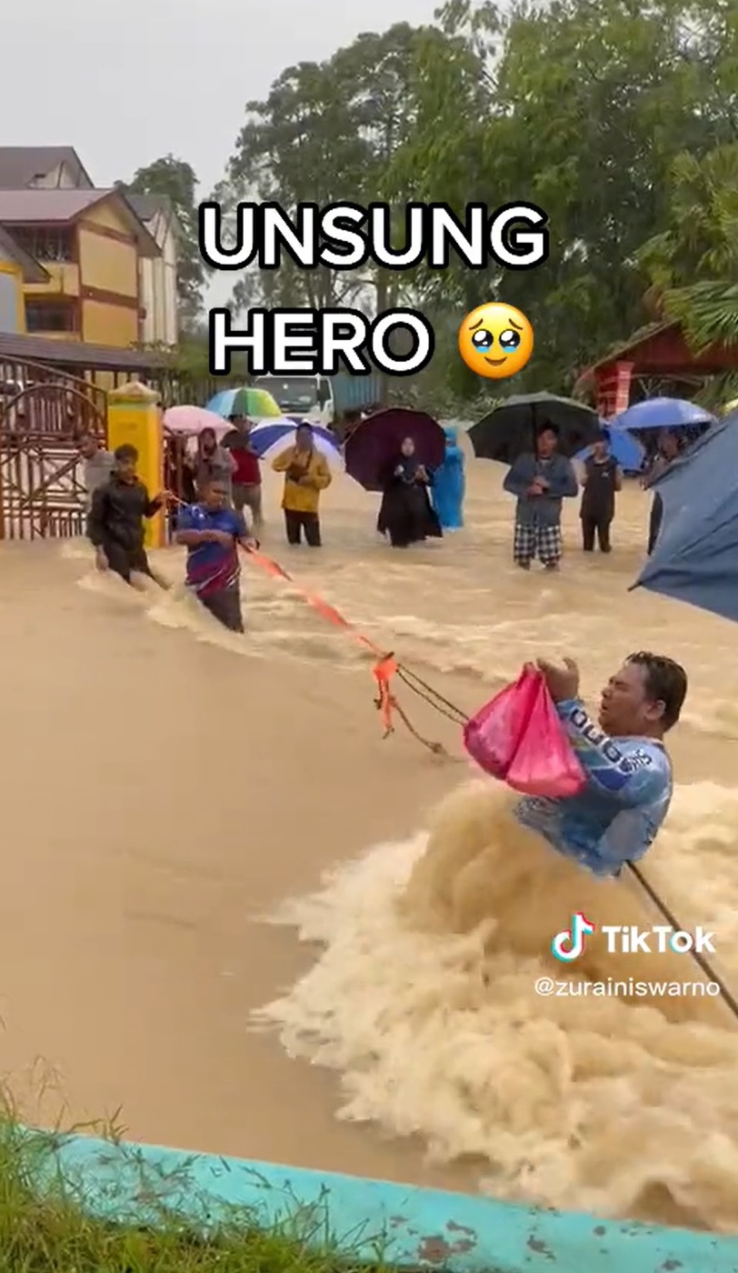 水位及腰 男子抓绳索冒险送食物