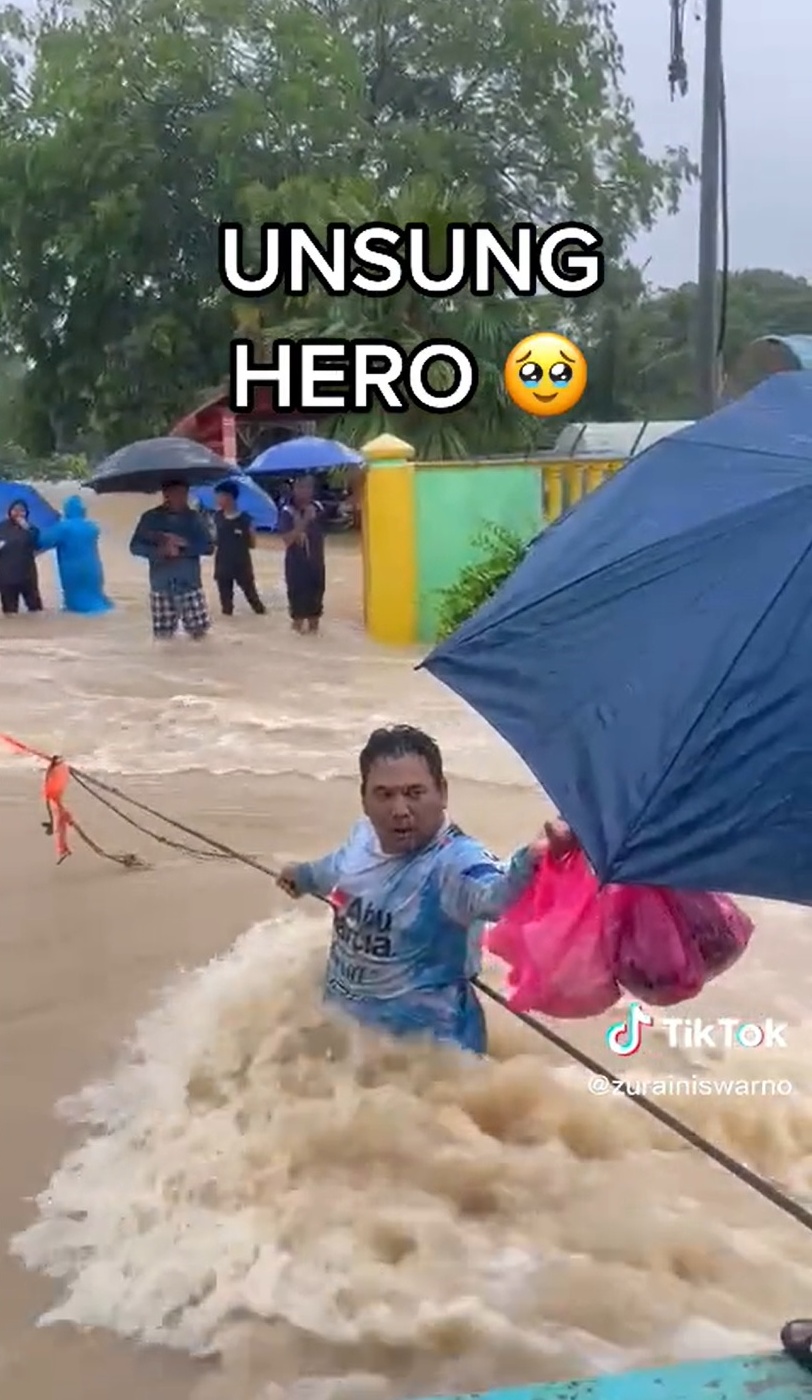 水位及腰 男子抓绳索冒险送食物