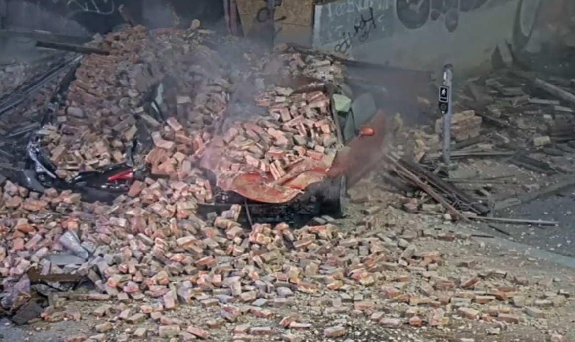 轿车逃追捕撞公寓楼 二楼垮塌砖块埋车