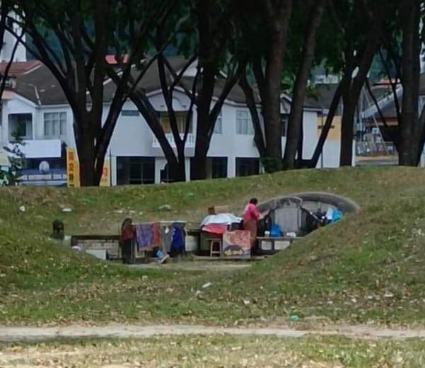 疑霸占百年坟墓当家,妇女放雨伞晾衣服