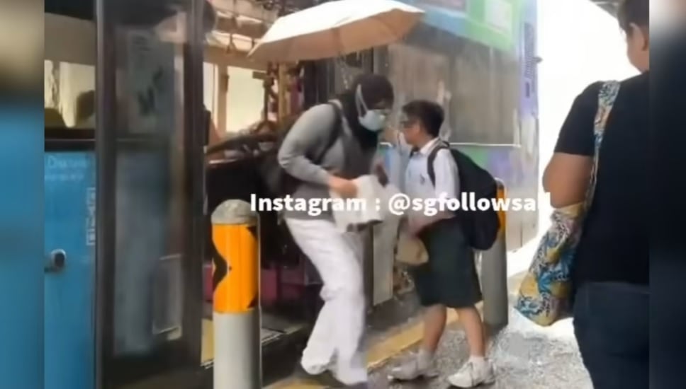 (已签发)柔:狮城二三事:男孩巴士车站撑伞为乘客挡雨 网民:非常有教养