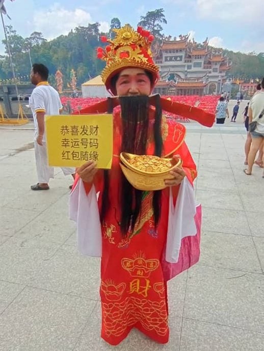 NS庇朥 / 庇朥西天宫女财神爷分发幸运号码结缘,成为善信们打卡留念焦点人物。
