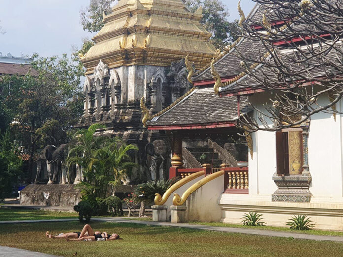 在寺庙外晒日光浴被轰不尊重 两游客道歉