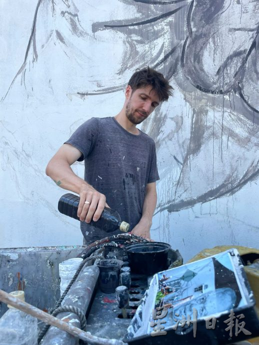 恩尼斯修复“老人喝白咖啡”壁画 直呼天气太热了