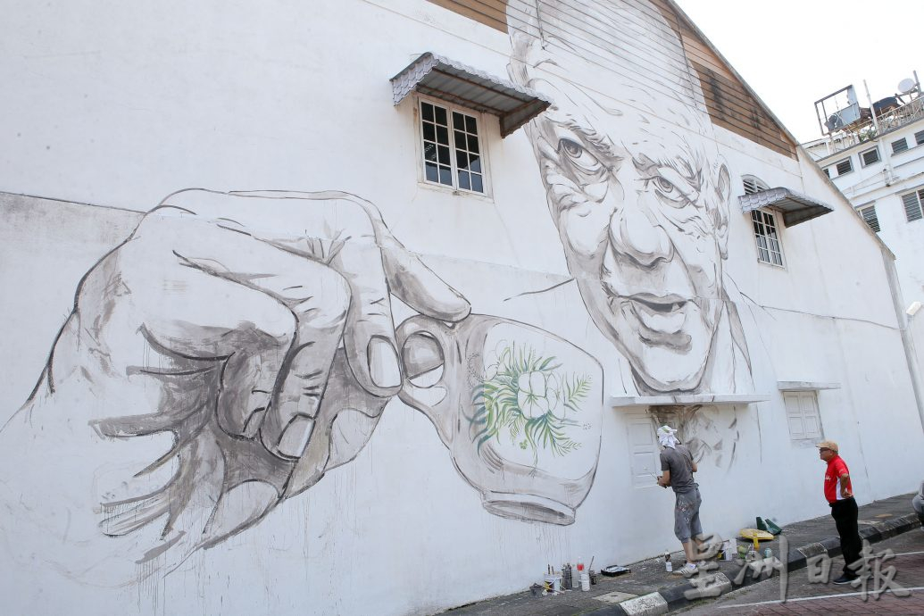 恩尼斯修复“老人喝白咖啡”壁画 直呼天气太热了