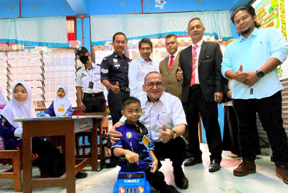 来自丹州哥打峇鲁的7岁男童阿都哈金天生患有脑瘫疾病,先天性行动不便,第一天上学以玩具车代步。