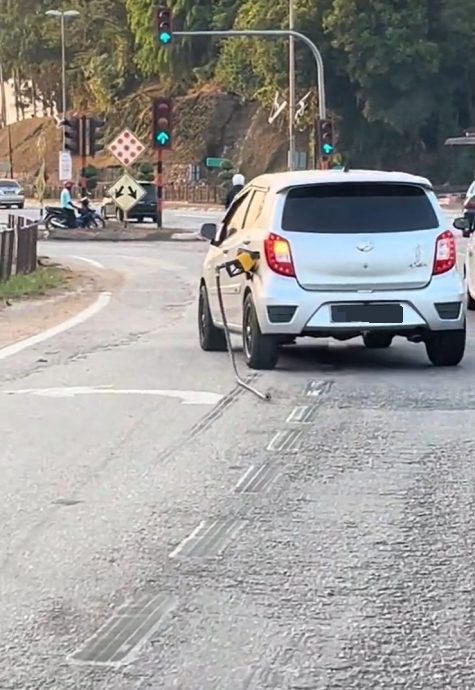 油枪插油箱口 油管拖马路 网民：Axia司机赶时间