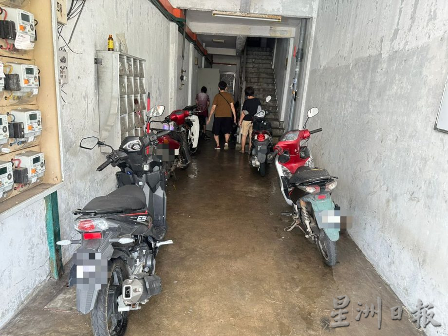 男子霸占楼梯口当修车厂 摩托车杂物堆积形阻碍