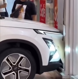 男童溜进车玩耍乱踩油门 展示车冲撞商场店外墙