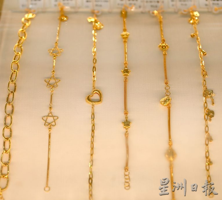 金价创新高 有人买金块保值 有人卖掉旧金饰