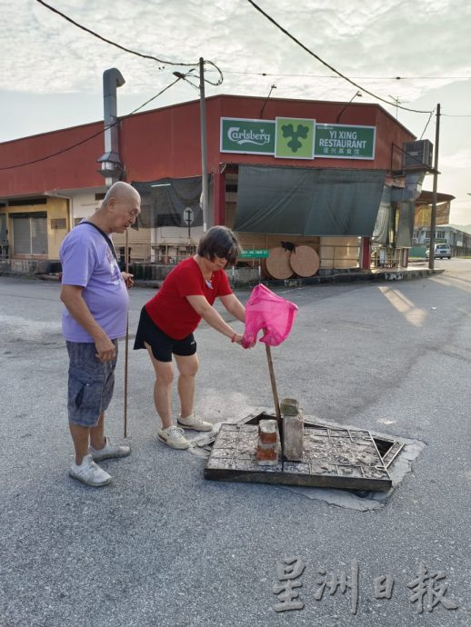 老妇插木棒竖木板警示 山景园一夜掀3井盖偷电缆
