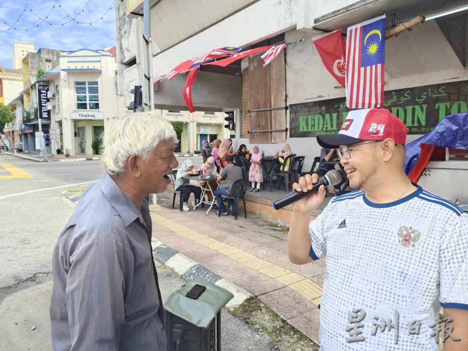 东:马来西亚日的哥市街头,一名驻唱的白发老伯在茶餐室前面开嗓献艺,他应客人要求唱了一首生日歌,仿佛也在歌唱自己的乐天和家国的欢腾,令人动容。