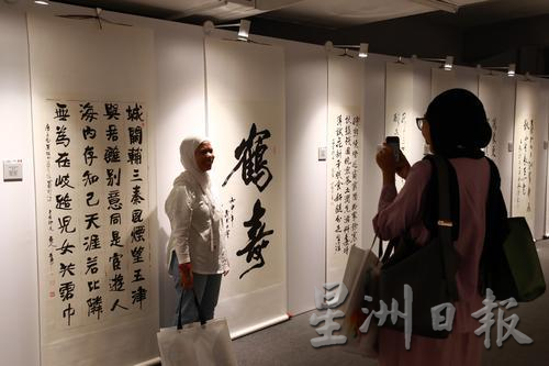 中华书法艺术作品也深获友族同胞的喜爱,她们在马中建交50周年书法交流展作品前留影。(苏思旗摄)hf241102w14