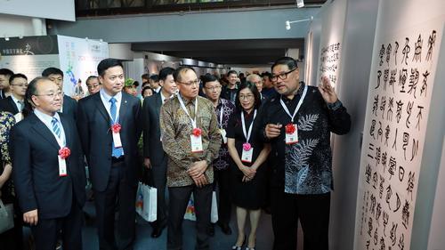 欧阳玉靖(前排左起)、李昕、莫哈末尤斯里参观“马中建交50周年书法交流展”的名家作品,并听取黄瑞庆(右一)的解说。前排右二为曾丽珠hf241102w11