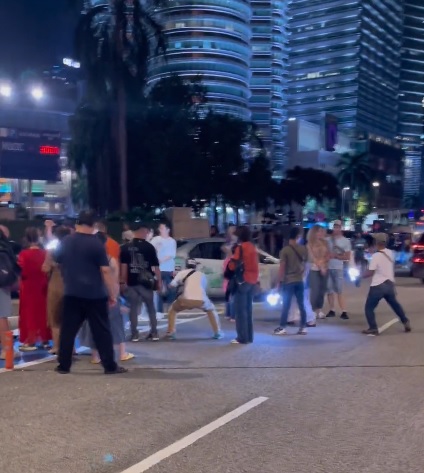 视频|懒理被喝阻霸占车道 游客坚持站路中跟KLCC合照