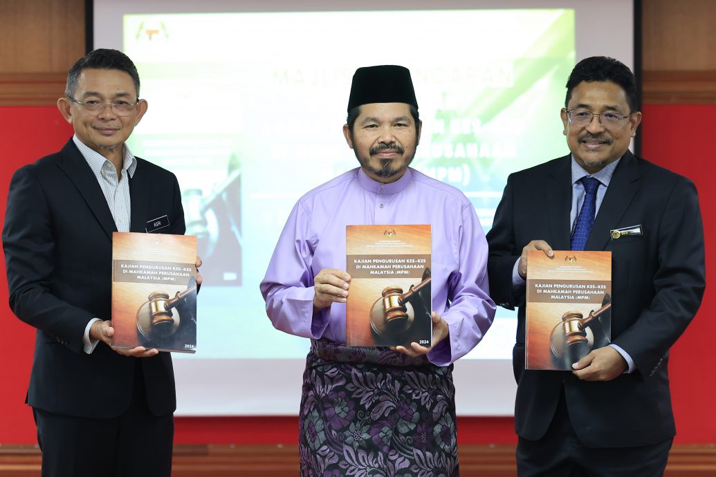 乌兹尔（中）把大马工业法庭案件管理统计调查报告移交给旺杰夫（右）。左为阿斯里。