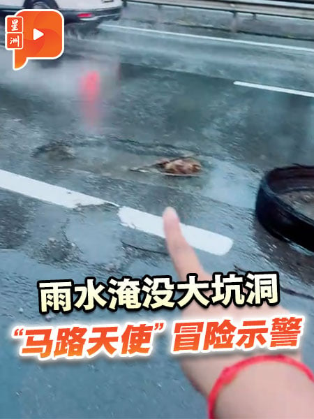 雨水淹没大坑洞 “马路天使”冒险示警