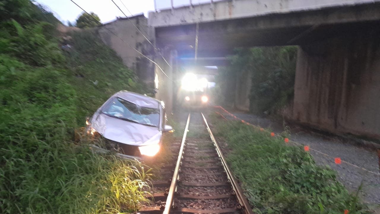 轿车“跌入”电动火车轨道旁 服务一度中断