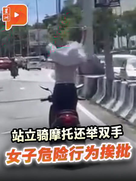 站立骑摩托还举双手 女子危险行为挨批