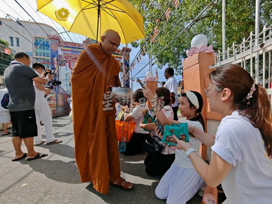（古城第三版主文）卫塞节民众游客到佛教场所浴佛祈福，非常热闹