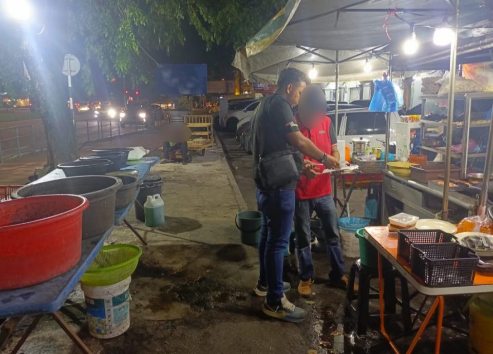 （大北马）路边摊小贩随意丢弃食物残渣，且直接将废油倒入路旁沟渠，被执法员开罚单。