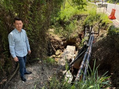 防护栏也滑落入沟 . 锦绣山庄路段土崩 危险