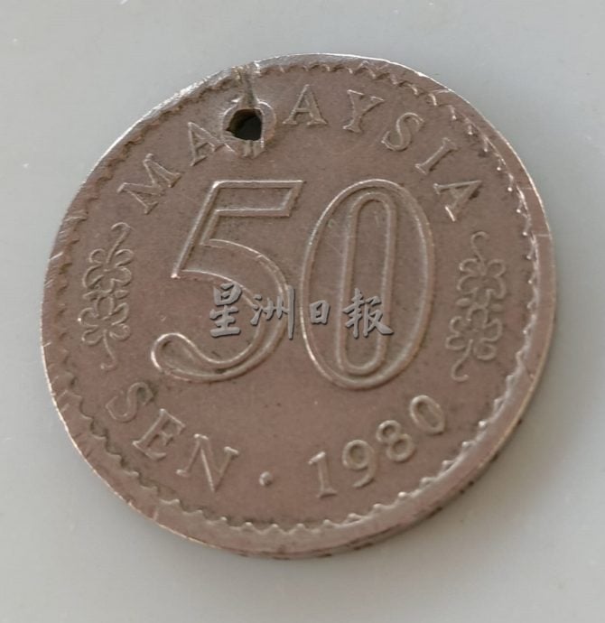 供星洲网:50仙硬币被打出小洞,小贩拒收