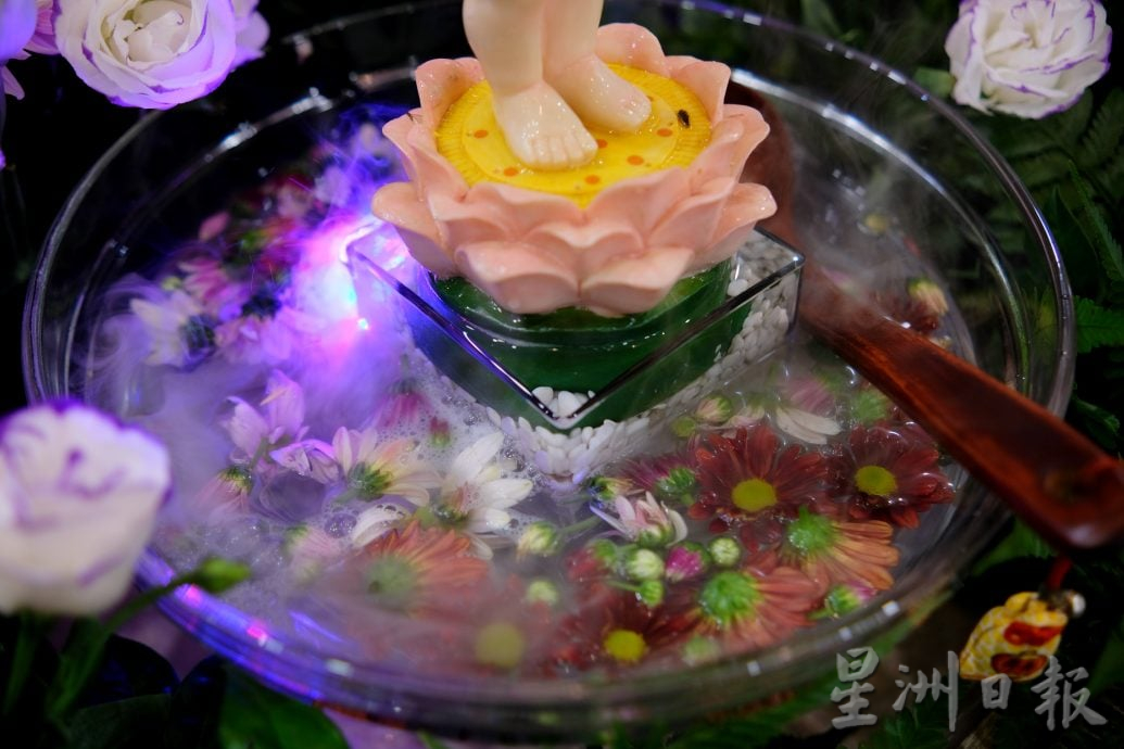 （22/6见报）星角摄（未签发）：卫塞节花香满寺，心敬佛恩。