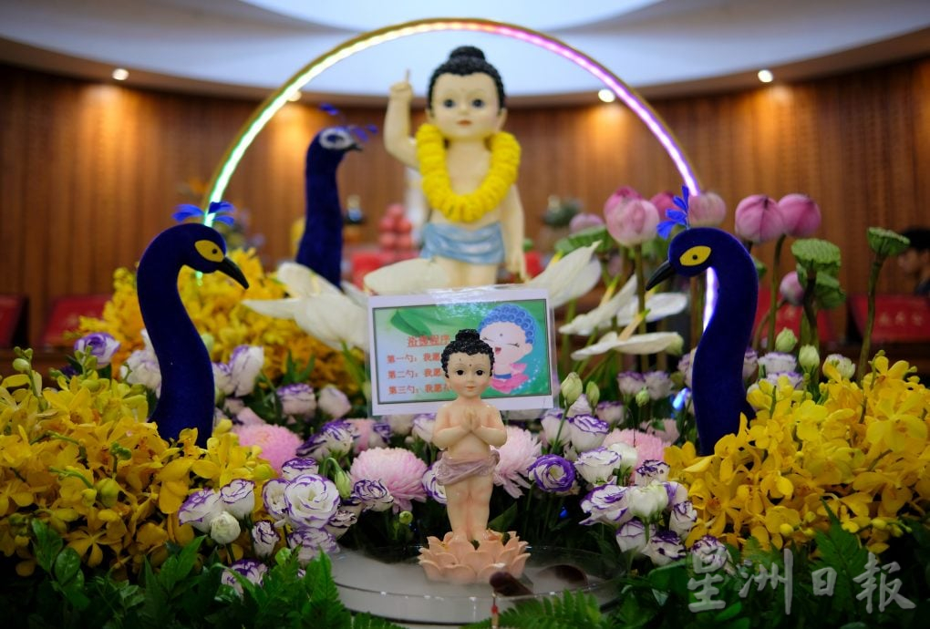 （22/6见报）星角摄（未签发）：卫塞节花香满寺，心敬佛恩。