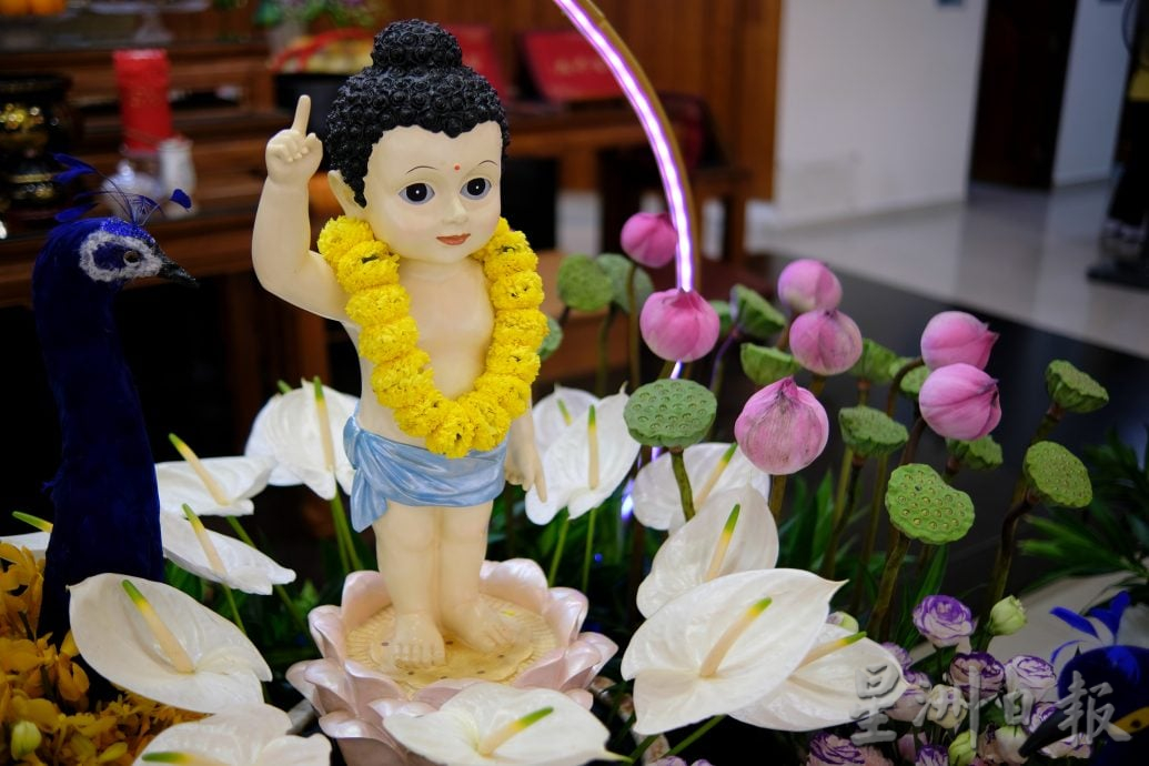 （22/6见报）星角摄（未签发）：卫塞节花香满寺，心敬佛恩。