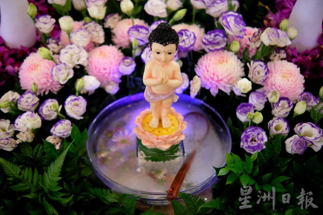 （22/6见报）星角摄（未签发）：卫塞节花香满寺，心敬佛恩。