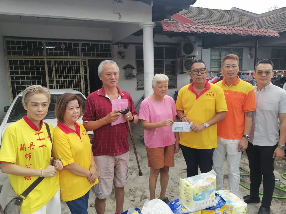 关丹慈善家与师公坛捐助中风病患李文财。 