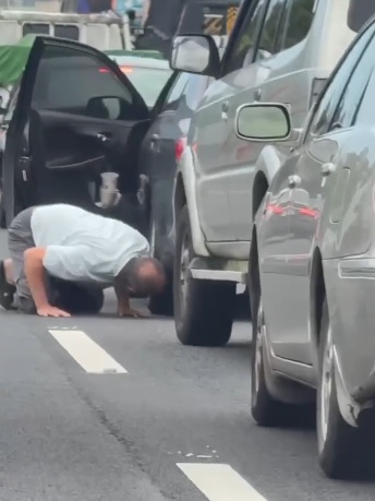 视频|趴车底找贵重东西? 男子车龙中救出小猫咪