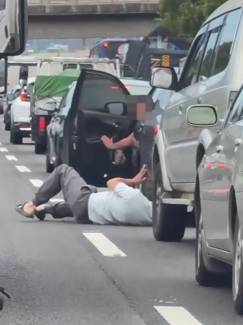 视频|趴车底找贵重东西? 男子车龙中救出小猫咪