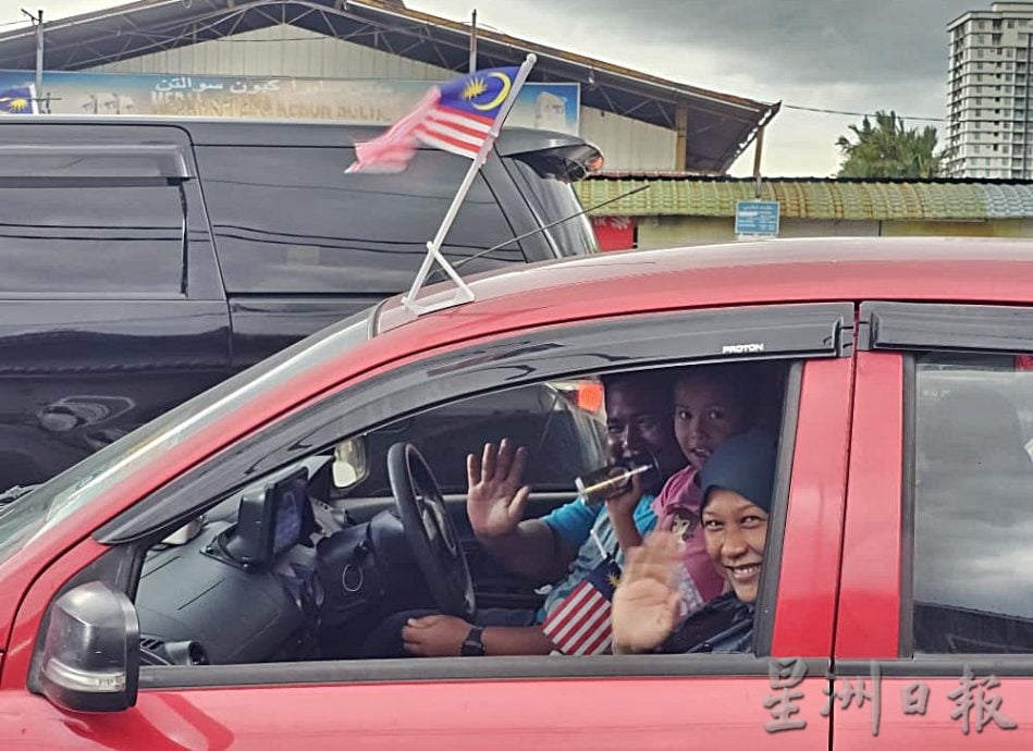 东(已签):哥打峇鲁伊党拥护者大会堂派发小国旗给车主、骑士。