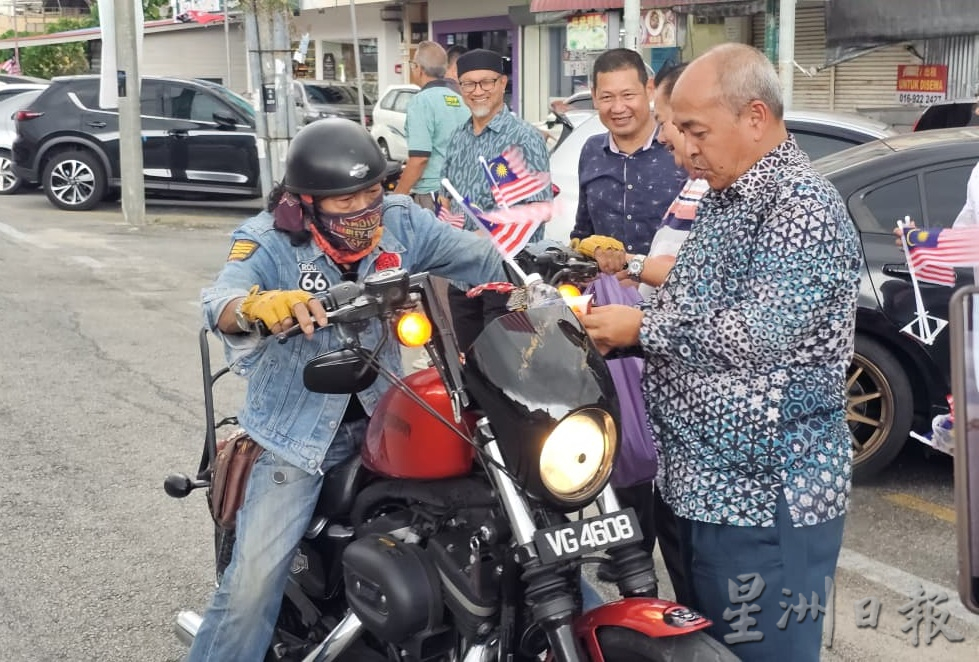 东(已签):哥打峇鲁伊党拥护者大会堂派发小国旗给车主、骑士。