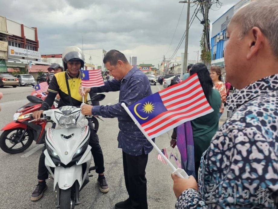 东(已签):哥打峇鲁伊党拥护者大会堂派发小国旗给车主、骑士。